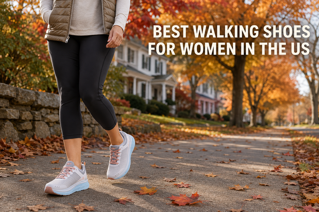 New England suburban street, full autumn colour, clapboard home defocused behind a stone wall, leaves scattered across the sidewalk. Oat quilted vest over black leggings nails autumn.